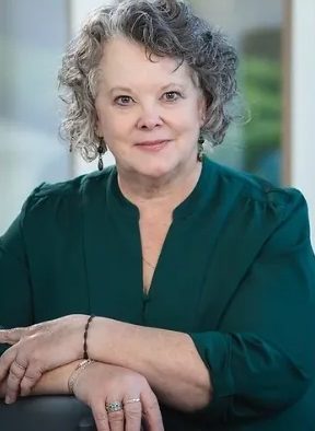 A woman with curly hair and green shirt